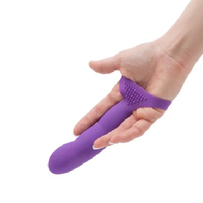 A hand holding the Simple and True Silicone G-Spot Finger Extender by BMS Enterprises, a purple, curved personal massager featuring textured ridges on the underside. The device is ergonomically designed for targeted G-spot stimulation.