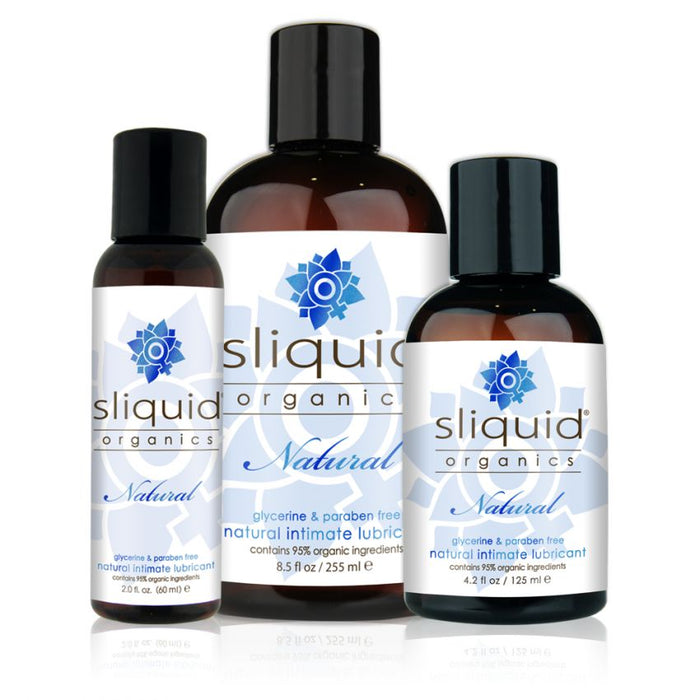 The image features three bottles of Sliquid Organics Natural Aloe Based Lubricant from the brand Sliquid. These glycerin and paraben-free lubricants are made with 95% organic ingredients. The lineup includes different sizes, with the largest bottle positioned in the back and two smaller ones in front.