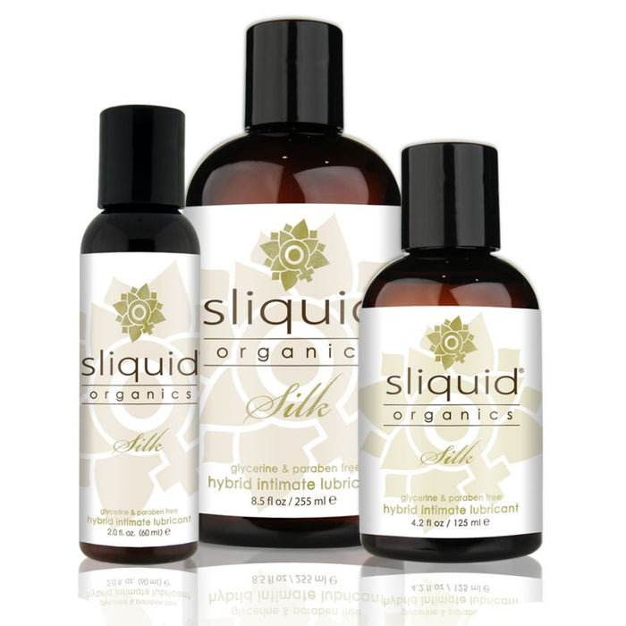 Three unmarked bottles of Sliquid Organics Silk Hybrid Lubricant in various sizes. Each bottle features a white label showcasing the Sliquid logo and product name. The labels emphasize that this long-lasting lubricant is glycerine and paraben-free, offering a natural and hypoallergenic experience.