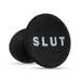 A black phone grip with the word "SLUT" in white capital letters on the round top, designed to match your bold style just like the Slut Silicone Butt Plug by Blush, made from premium platinum-cured silicone.