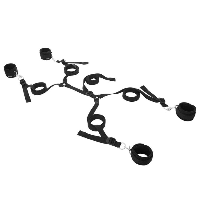 The Sportsheets Under the Bed Restraint System is a travel-sized set of black adjustable nylon wrist and ankle restraints with metal clasps and buckles, arranged in a spread-eagle position. Perfect for a bondage bedroom setup, this product features matching straps for secure connection.