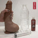 Squirting Realistic Cock Tan 9.2 Inches with a hand holding the dildo next to a standard water bottle to show size