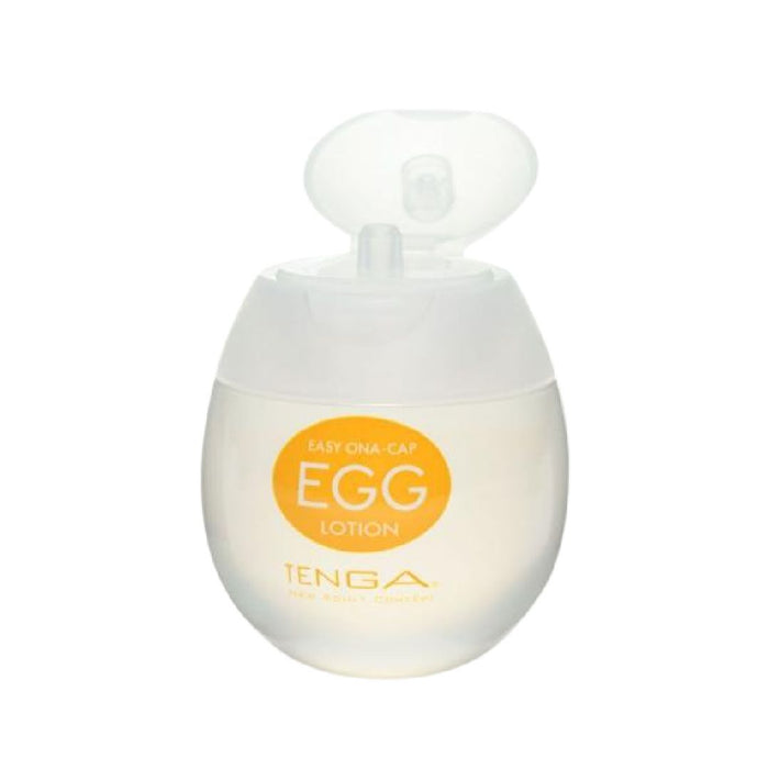 A clear, egg-shaped container with a white flip-top lid, labeled "Tenga Egg Disposable Penis Masturbator - Lotion" in an orange circle. The printed text reads "EASY ONA-CAP" above and "TENGA," featuring additional descriptions below. The container holds a liquid product, designed to complement the unique texture of your Tenga Egg.