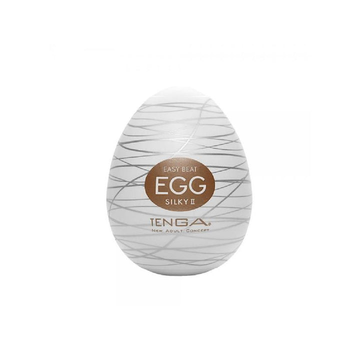 A white oval product with grey lines and a brown label reading "Tenga Egg Disposable Penis Masturbator - Silky 2" from Tenga, a New Adult Concept—your perfect travel buddy. This disposable masturbation sleeve is showcased against a plain white background.