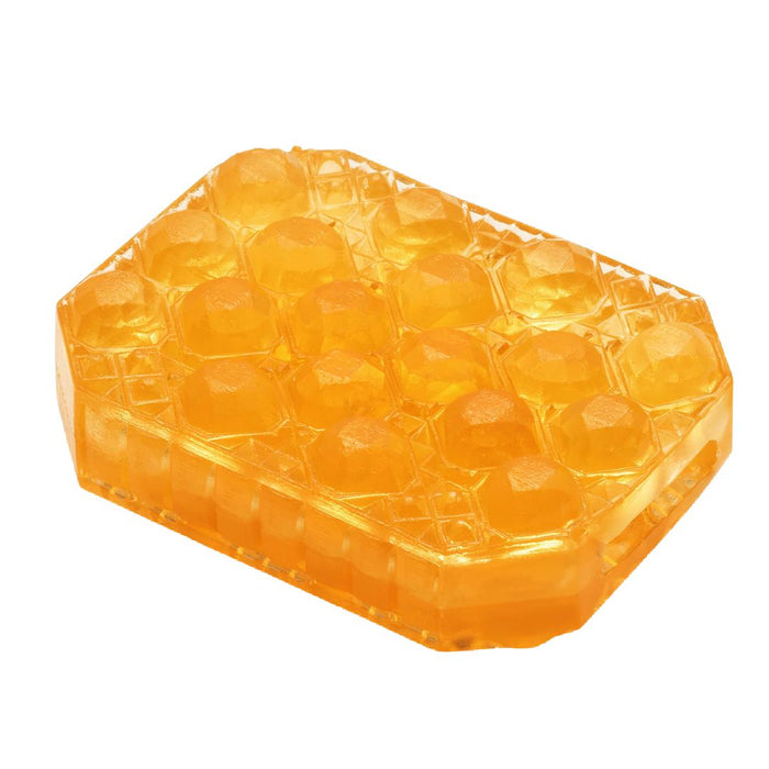 A translucent orange Tenga penis stroker with a honeycomb pattern embossed on the top, isolated on a white background.