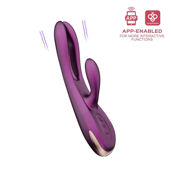 The Terri App-Controlled Kinky Finger Tapping Rabbit Vibrator in purple, from Honey Play Box, features a curved design with two stimulator arms for enhanced g-spot stimulation. It boasts app-enabled functionality for interactive use, supported by icons that indicate wireless and app connectivity. The smaller stimulator is positioned at a right angle to the main body and offers multiple vibrating modes.