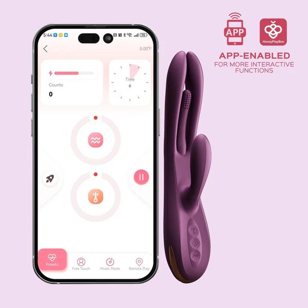 A smartphone displaying an app interface is next to the purple, dual-prong Terri App-Controlled Kinky Finger Tapping Rabbit Vibrator by Honey Play Box. The vibrator offers multiple vibrating modes and g-spot stimulation. The app interface shows options such as Presets, Music Mode, and Remote Play. The text reads, "APP-ENABLED FOR MORE INTERACTIVE FUNCTIONS.