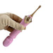 A hand holding the Nasstoys Goddess Double Ended Wand + Pinpoint Vibe with 3 Attachments in pink.