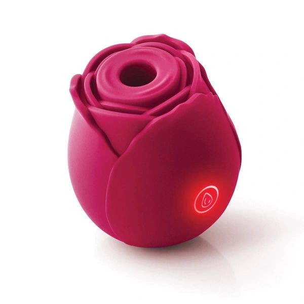 The Rose Powerful Clitoral Air Pulsation Vibrator by NS Novelties is a red, rose-shaped gadget with a central hollow opening. It features a circular power button and an illuminated indicator light below it. Designed for optimal clitoral stimulation, the device boasts a smooth surface and rests elegantly on a white background.