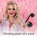 A woman with long blonde hair, bright makeup, and a shiny, iridescent top smiles while holding The Snail Ultra Powerful 2 Motor Dual Stimulating Vibrator in black. The background features fluffy, pink feathers. Text at the bottom reads, "Vibrating power of a dual stimulator by Snail Vibe.