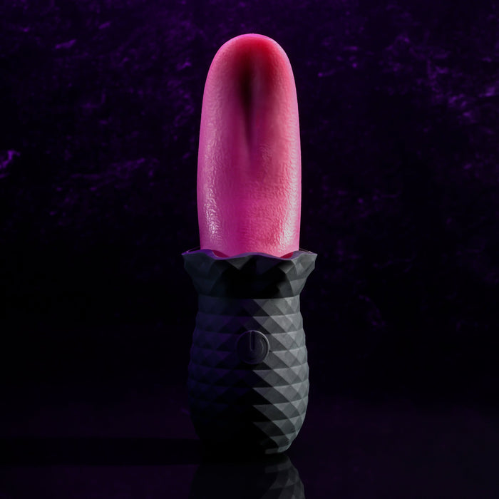 A close-up of the Evolved Novelties Tongue Teaser Flickering Realistic Red Tongue Vibrator with a textured black base, illuminated against a dark purple background. The prominently pink, flexible tongue stands upright, promising realistic oral sensations with its geometric-patterned base.