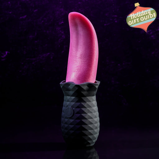 A black, textured base holding a realistic red tongue-like object stands vertically against a dark purple background. The Tongue Teaser Flickering Realistic Red Tongue Vibrator by Evolved Novelties offers lifelike oral sensations, combining the detailed ridged base with the smooth, glossy appearance of the red tongue shape.