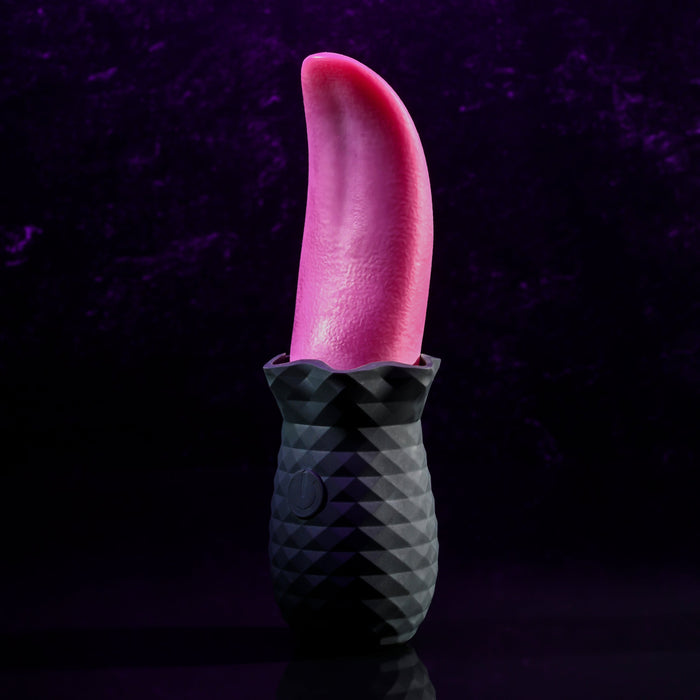 A black, textured base holding a realistic red tongue-like object stands vertically against a dark purple background. The Tongue Teaser Flickering Realistic Red Tongue Vibrator by Evolved Novelties offers lifelike oral sensations, combining the detailed ridged base with the smooth, glossy appearance of the red tongue shape.