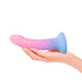 A hand holds the Lovely Planet Utopia Pink and Blue Ombre Silicone Dildo with an ergonomically curved shape against a white background.