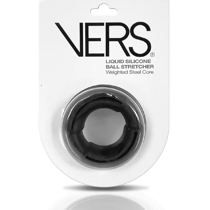 A packaged Vers VERS Silicone Ball Stretcher with Weighted Steel Interior - Black for enhanced sexual performance. The product is displayed on a white card with black text, positioned within a clear plastic blister pack. The ball stretcher is circular and black in color.