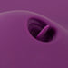 Close-up of the VibePad 2 Ride On Hands-Free Humping Vibrator with Licking Tongue by Orion, showcasing its purple hue with a small, pointed protrusion emerging from a recessed area. The abstract composition and focus on texture and shape make it difficult to identify the object, though it vaguely resembles a remote control vibrator.