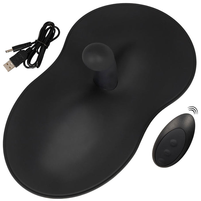 A black ergonomic computer mouse pad with an attached wrist rest, featuring a raised, rounded support area. This VibePad 3 Ride On Hands-Free Humping Vibrator with G-Spot Probe by Orion includes a vibrating pad and comes with a small, wireless remote control with three buttons and a USB charging cable.