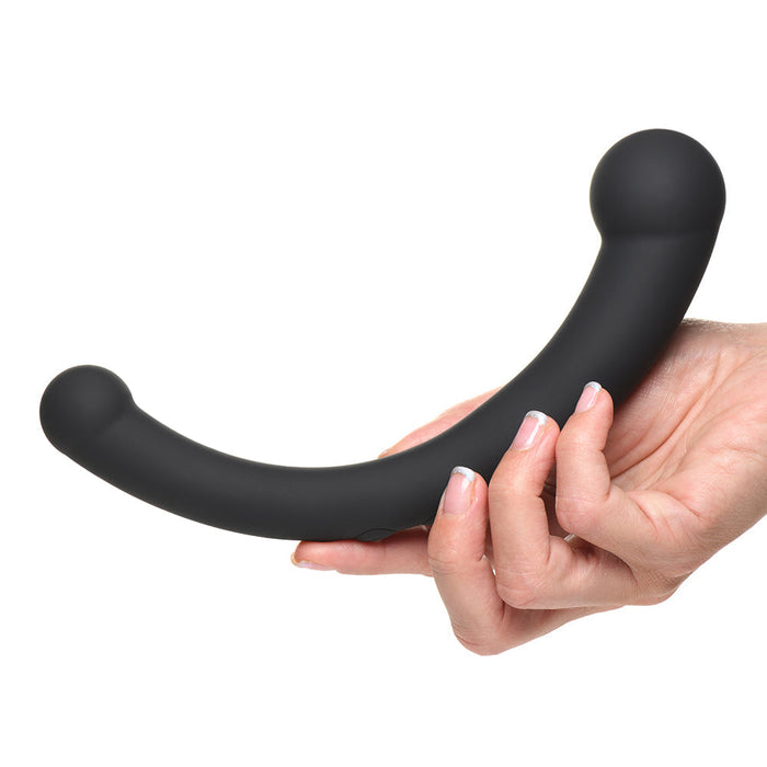 A hand holding the Vibra Crescent Powerful Silicone Double Ended Vibrator by XR Brands. The ergonomic, curved black silicone dildo features bulbous tips on both ends. The plain white background accentuates the sex toy and the hand holding it.