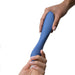 A hand is passing a blue, ergonomically designed We-Vibe Rave 2 Powerful Adjustable G-Spot Vibrator with button controls to another hand. The customizable vibrator from We-Vibe promises powerful vibrations, set against a plain white background.