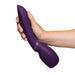 A hand holding the We-Vibe Wand 2, a purple cordless vibrator featuring a bulbous end and sleek design, against a white background.