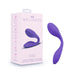 A purple wellness product from Blush called the "Wellness Duo Hands Free Wearable and Couples Vibrator," showcasing a modern, curved design, is displayed beside its pink and white packaging box. The box highlights features such as being rechargeable, waterproof, and made of premium silicone for the perfect vibe.