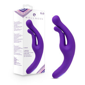 A purple ergonomic wellness device, the Blush Wellness G Wave Waterproof Rabbit Vibrator with Ergonomic Handle, is displayed next to its packaging. The waterproof device has a curved design with a split end for ergonomic clit and g-spot hugging. The box features product information, branding, and a photo of the device.