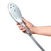 A hand holding the Womanizer Wave Water Pulsing Shower Masturbator (Chrome) by Womanizer against a white background. This modern, silver showerhead offers multiple spray settings and doubles as an invigorating water massager for clitoral stimulation.