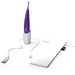 Image of a Zumio X Powerful Oscillating Rechargeable Clitoral Stimulator with a purple handle placed in a white charging dock. A USB charging cable is connected to the dock, and a white drawstring travel pouch is lying beside it. Enhanced with Spiro Tip Technology, the setup appears ready for use or travel.