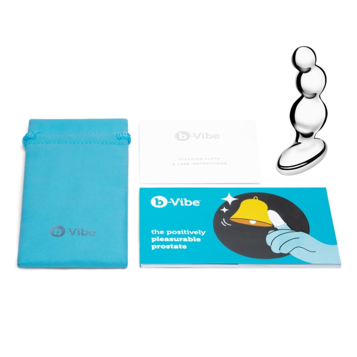 An image of the b-Vibe Stainless Steel Weighted Anal Beads for Prostate featuring a beaded design. It includes a blue drawstring storage bag, a white cleaning cloth with care instructions, and a blue pamphlet titled "the positively pleasurable prostate" with a bell and hand illustration, perfect for prostate stimulation.