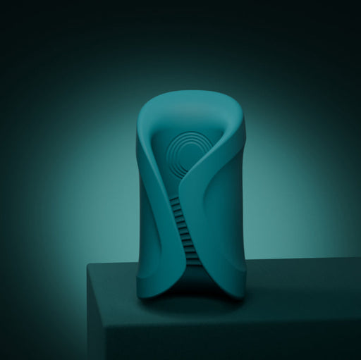 A sleek teal Lovense Gush 2 oscillating masturbator with smooth curves and a circular pattern stands on a dark surface against a gradient teal background, offering modern design and app compatibility for a hands-free experience.