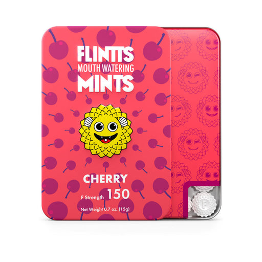 A pink tin of Flintts Mouth Watering Mints - Cherry by Flintts Mints showcases a yellow, spiky cartoon face with cherries in the background, highlighting its cherry flavor and vegan-friendly attributes. The tin indicates "150 F Strength" and has a net weight of 0.7 oz (15g), making it an ideal dry mouth solution with a visible peek of the mints in the corner.