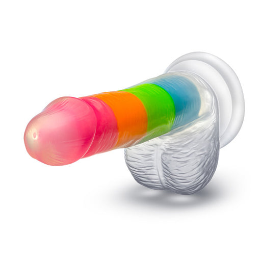 Introducing the Rainbow Rave Glow in the Dark 6.5 Inch Silicone Dildo by Blush, featuring a realistic shape and feel. This silicone wonder boasts a vibrant, rainbow-striped design with translucent shades of pink, red, orange, green, and blue for exciting adventures any time. Complete with a suction cup base for added versatility.