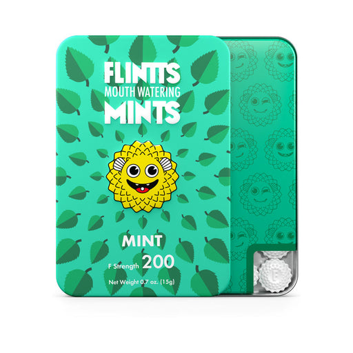 Tin of Flintts Mouth Watering Mints in mint flavor from Flintts Mints, ideal for alleviating dry mouth. The packaging is vegan-friendly and green with a leaf pattern, showcasing a yellow, spiky cartoon character with large eyes. A window reveals some sparkly mints inside.