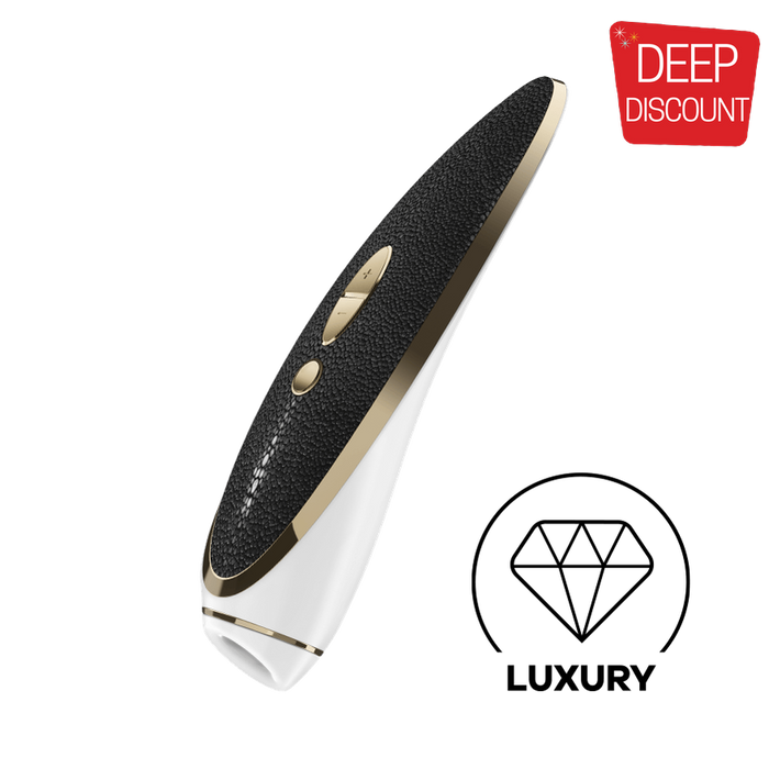 Introducing the Satisfyer Luxury Air Pulsation + Vibration by Satisfyer, a chic and contemporary handheld electronic device. It features a textured black leather top with elegant golden edges, complemented by an ergonomic handle for easy use. At the center, a button is set within a small screen on a pristine white background, offering both style and comfort in an innovative design.