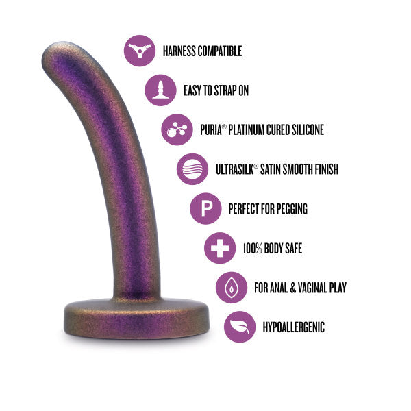 The Surrender Slim 4.75 Inch Silicone Beginner & Pegging Dildo by Blush, shown in purple with a curved shape and flared base, features icons that highlight its harness compatibility for pegging, easy strap-on use, Puria™ platinum cured silicone craftsmanship, and an Ultrasilk™ finish. It's body-safe and hypoallergenic, making it perfect for both anal and vaginal play.