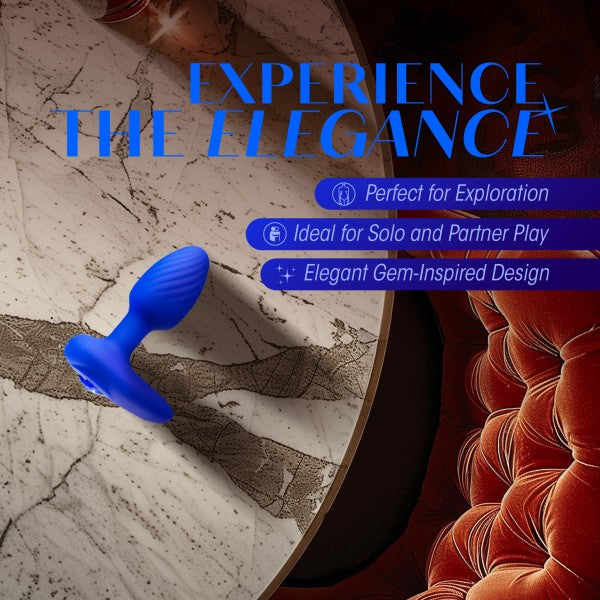 A blue, gem-inspired Mystery Vibrating Textured Silicone Butt Plug in Sapphire by Blush is displayed against a marble background with the text "Experience the Elegance" above it. Features listed include "Perfect for Exploration," "Ideal for Solo and Partner Play," and "Elegant Gem-Inspired Design.