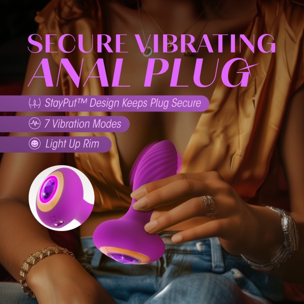 A person in a golden shirt holds the Charm Vibrating Textured Silicone Butt Plug in Amethyst by Blush, which features a purple design crafted from platinum-cured silicone and a light-up rim. The image is overlaid with text: "Secure Vibrating Anal Plug. StayPut™ Design Keeps Plug Secure. 7 Powerful Vibration Modes. Light Up Rim.