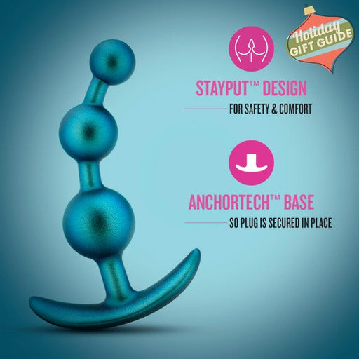 Displayed is the Gamma Silicone Anal Beads & Butt Plug by Blush in a blue silicone material featuring a beaded design. The text highlights its "STAYPUT™ Design for Safety & Comfort" and "ANCHORTECH™ Base so Plug is Secured in Place," focusing on its safety and security features. Discover prostate pleasure with this innovative anal toy.